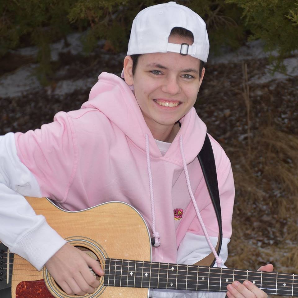 Demetra in a pink and white sweatshirt and backwards white hat